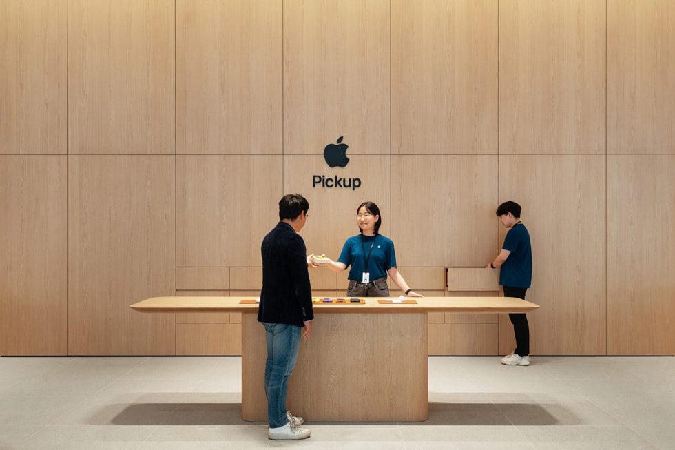 Apple 강남의 픽업 공간, 테이블, 목재 벽을 보여주는 사진.