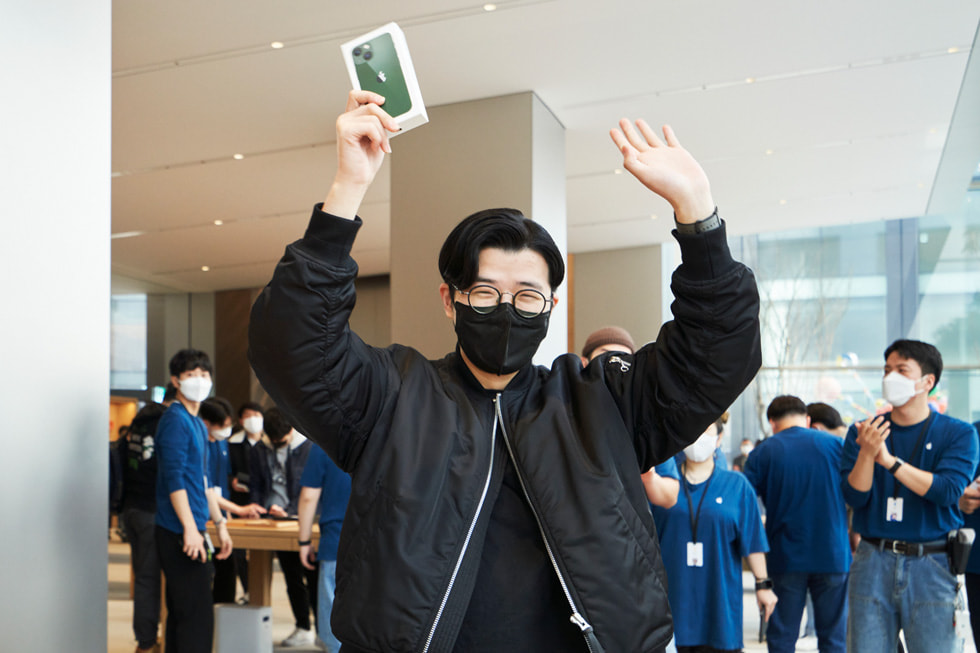 Apple 명동 개장 날 새로 구매한 iPhone 13을 자랑하는 고객의 모습.