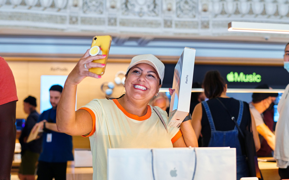 En kunde fejrer, at hun har købt en ny iPad Pro, ved at tage en selfie i Apple Tower Theatre.