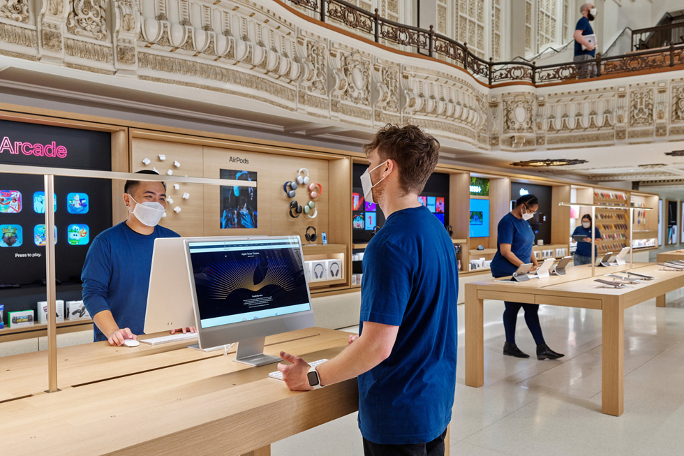 Apple Tower Theatre satış ekibi üyeleri iMac ve iPad istasyonlarında.
