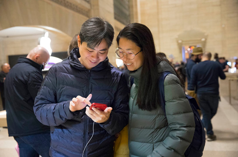 新登場のPRODUCT(RED)仕様のiPhone XRを一緒に試す2人のお客様。