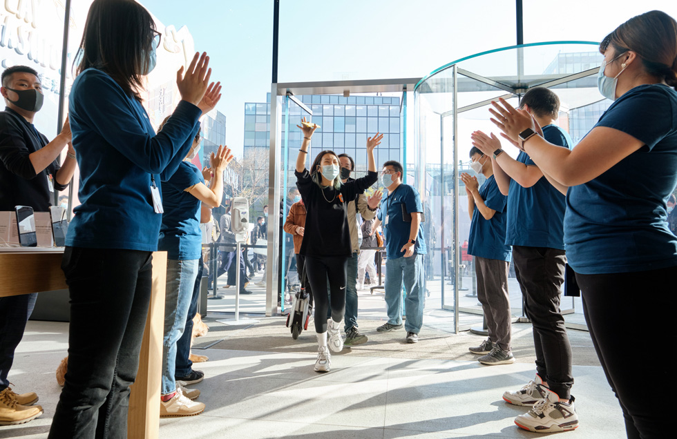 Apple Sanlitunで、到着したばかりのiPhone 12 Pro MaxとiPhone 12 miniの会計をするお客様を迎えるチームメンバー。