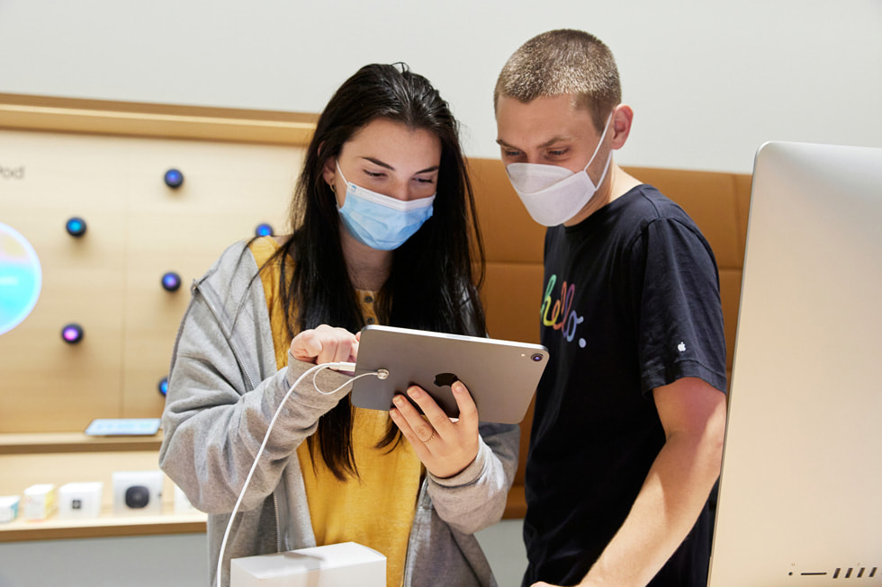عميلان شابان يتفقدان جهاز iPad mini الجديد داخل متجر Apple Bay Plaza.