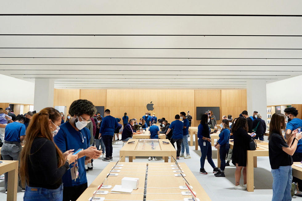 العملاء وأعضاء فريق Apple حول طاولات العرض في متجر Apple Bay Plaza.