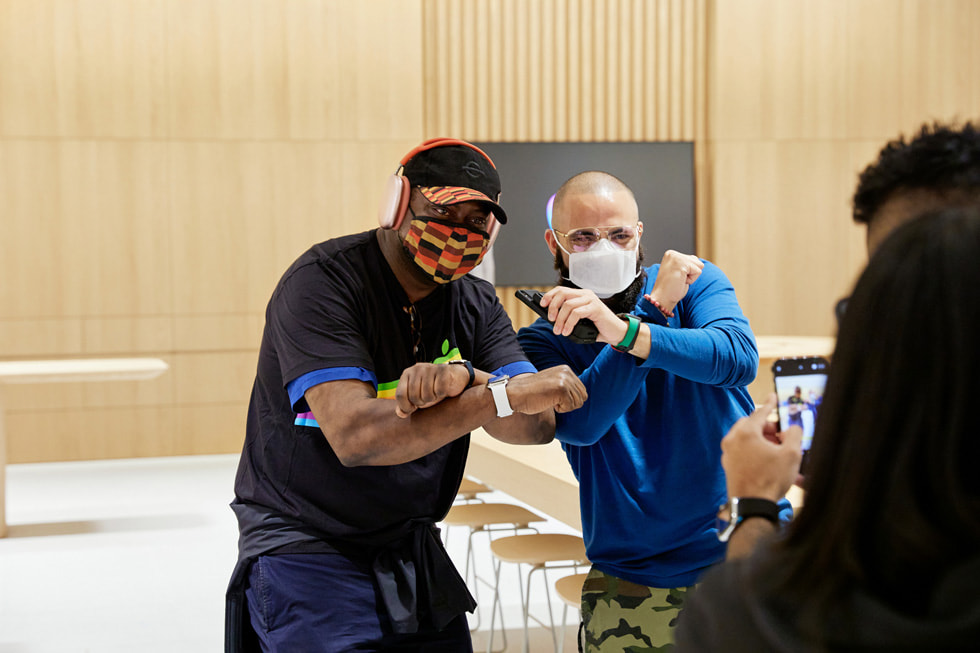 عميل وأحد أعضاء فريق متجر Apple Bay Plaza يلتقطان صورة لهما باستخدام iPhone وههما يقومان بحركة Bronx.