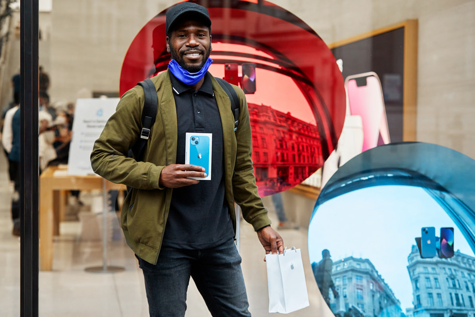 أحد عملاء متجر Apple Regent Street يتباهى بشراء جهاز iPhone 13 الجديد. 