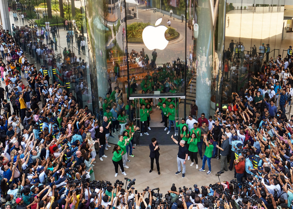 Tim Cook, Deirdre O’Brien i personel sklepu oklaskują pierwszych klientów przed salonem Apple BKC.