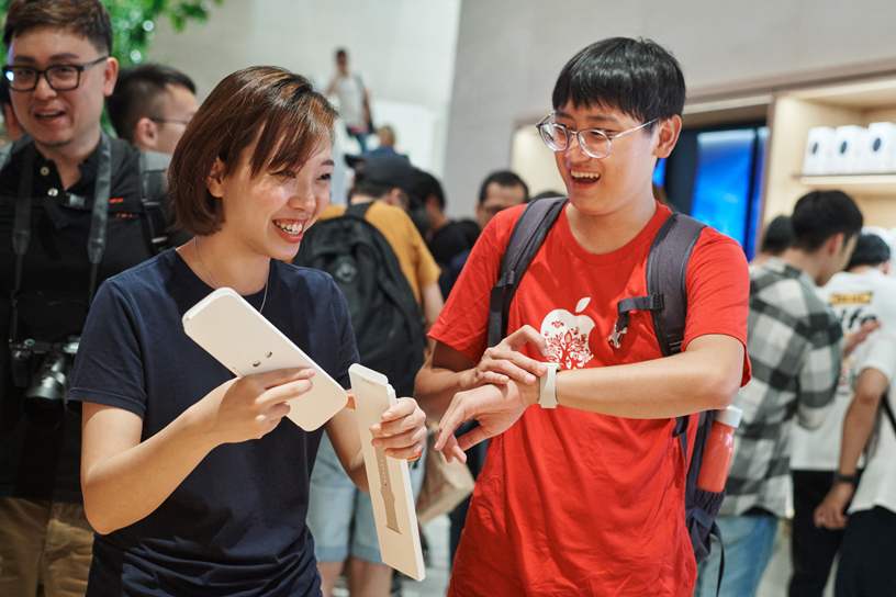 إحدى أعضاء فريق العمل في متجر Apple Xinyi A13 تساعد عميلاً في استخدام Apple Watch.
