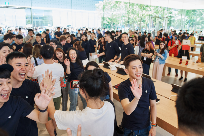 أعضاء فريق العمل والعملاء داخل متجر Apple Xinyi A13.