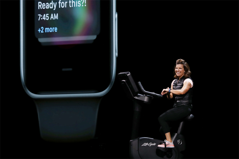 Julz Arney WWDC 2018’de sahnede kondisyon bisikletine binerek watchOS’un demosunu yapıyor.