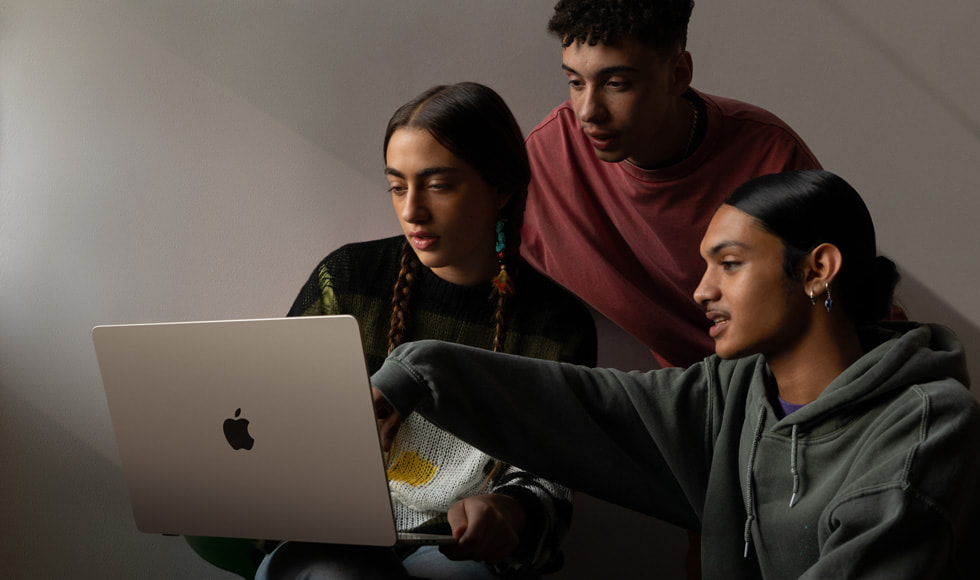 Tři lidé se dívají na displej 15palcového MacBooku Air.