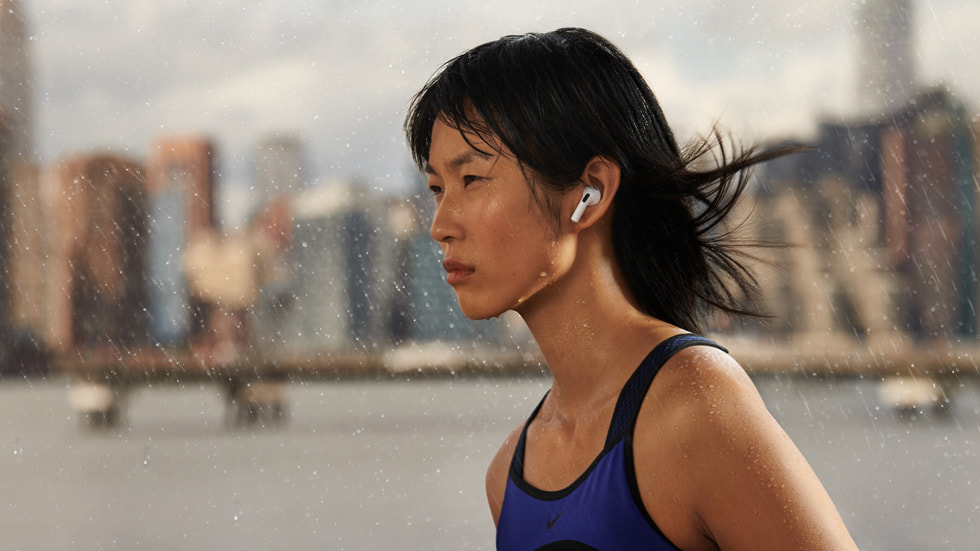 Yağmurda AirPods (3. nesil) takan bir kadın.