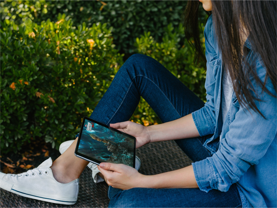 Woman watching movie on iPad outdoors.