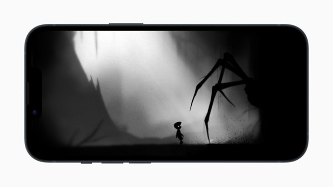 iPhone 14’te, Playdead’in LIMBO+ oyununda gölgeler içinden küçük bir çocuğa yaklaşan dev örümceği gösteren bir görüntü.