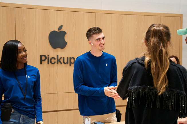 Apple-medarbetare hjälper kunder som hämtar sina varor i hämtningszonen på Apple Store.