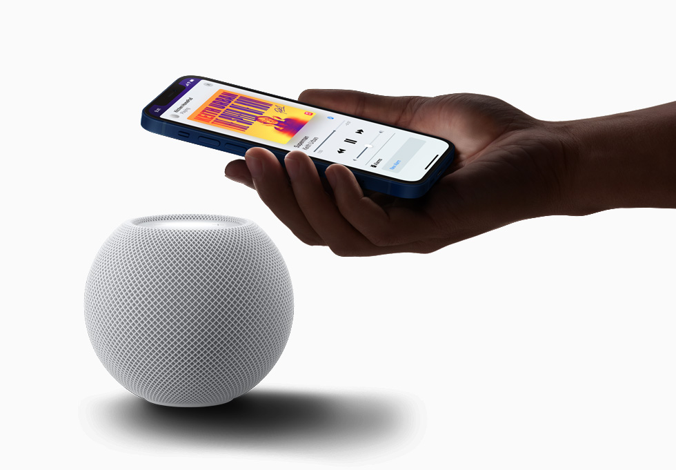 iPhone 12’sini HomePod mini’nin yakınında tutan bir kullanıcı.