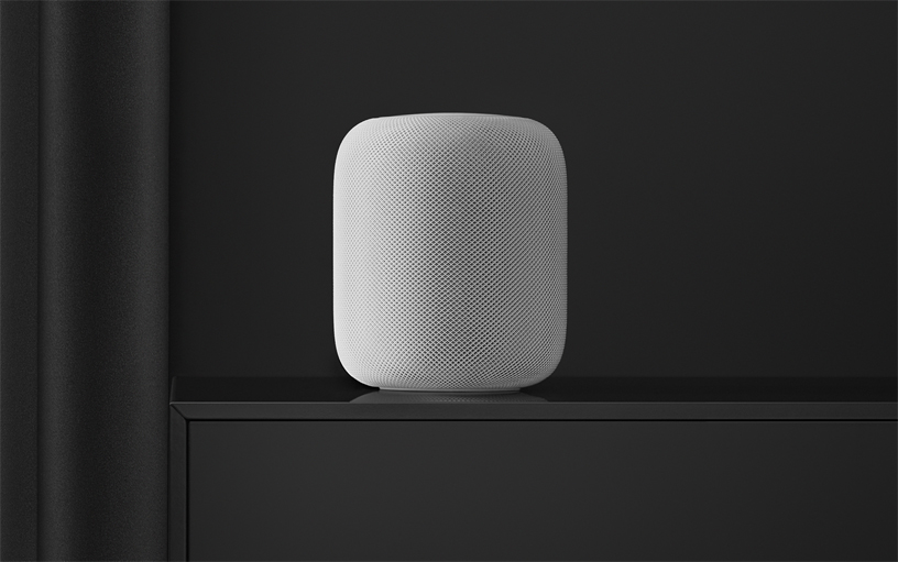 Siyah bir rafın üzerinde beyaz HomePod hoparlör.