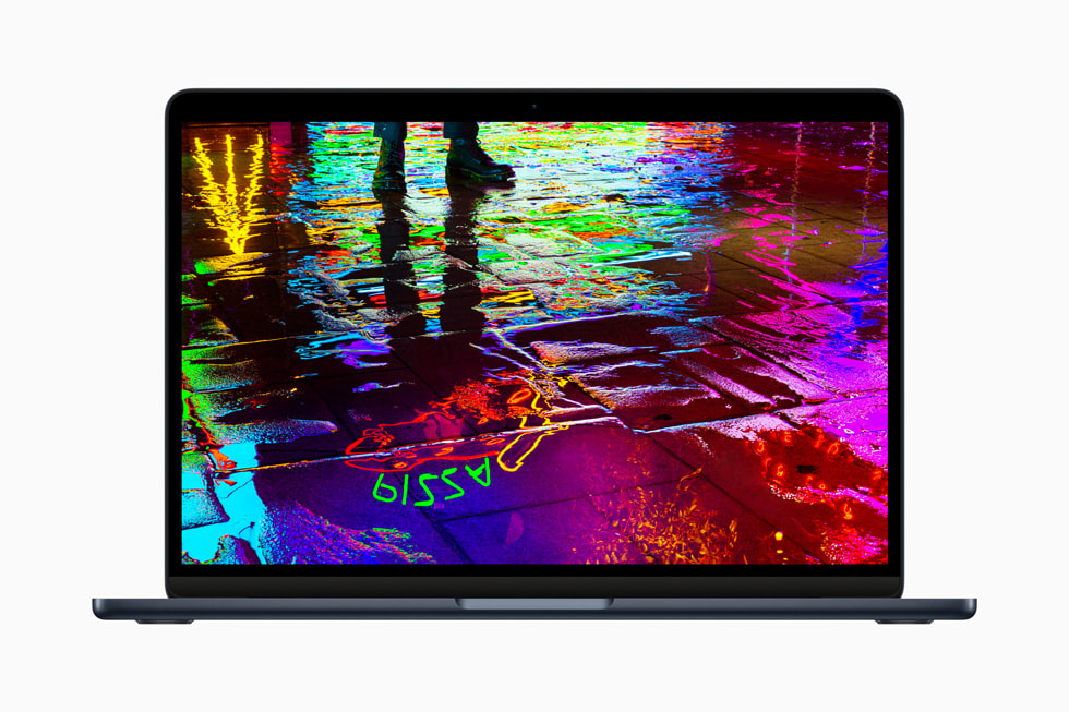 젖은 노면에 반사된 네온 불빛 이미지를 보여주는, M2를 탑재한 새로운 MacBook Air의 화면. 