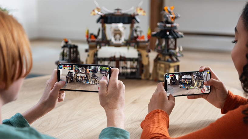 iPhone’da bir AR oyunu oynayan iki çocuk.