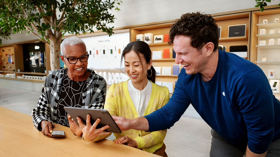 أحد مختصي Apple يساعد العملاء على استخدام iPad Pro داخل متجر Apple Store.
