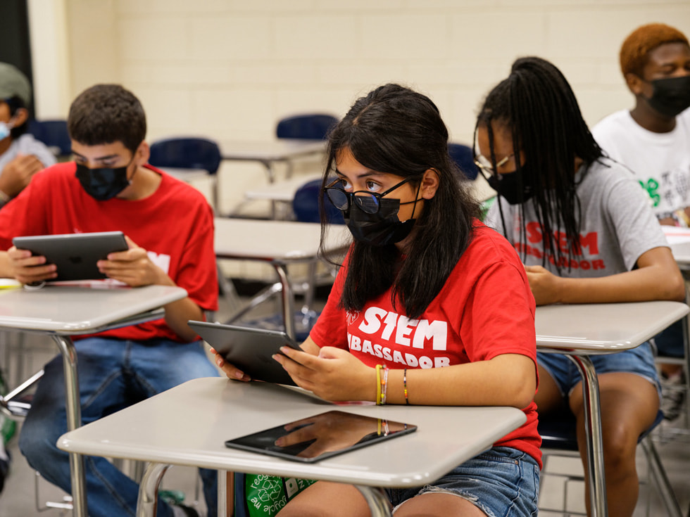 يجلس الطلاب على المكاتب ويستخدمون أجهزة iPad في برنامج Rutgers 4-H Computers Pathways.