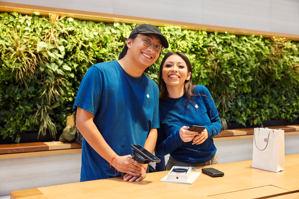 테이블 뒤에서 미소 짓고 있는 Apple 스페셜리스트.