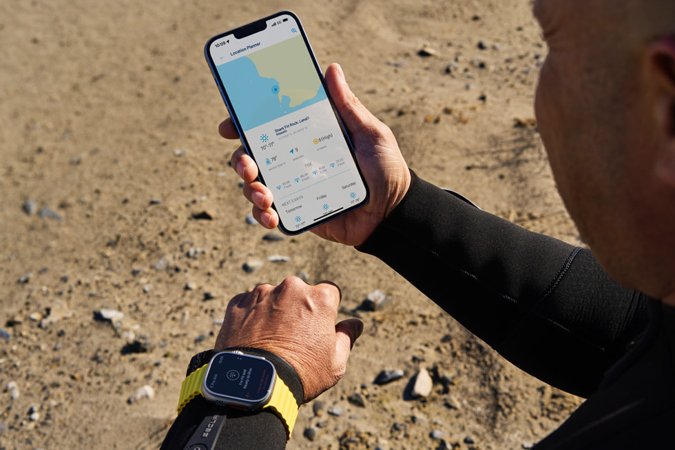 Apple Watch UltraのOceanic+アプリケーションを見ているダイバー。