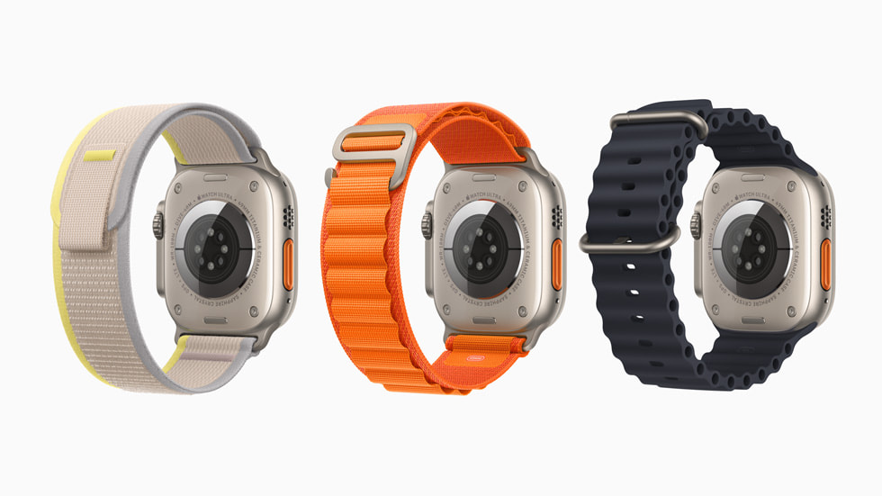 Gri ve sarı Trail Loop, turuncu Alpine Loop ve siyah Ocean Kordon dahil olmak üzere üç farklı kayışa sahip üç adet Apple Watch Ultra arkadan gösteriliyor. 