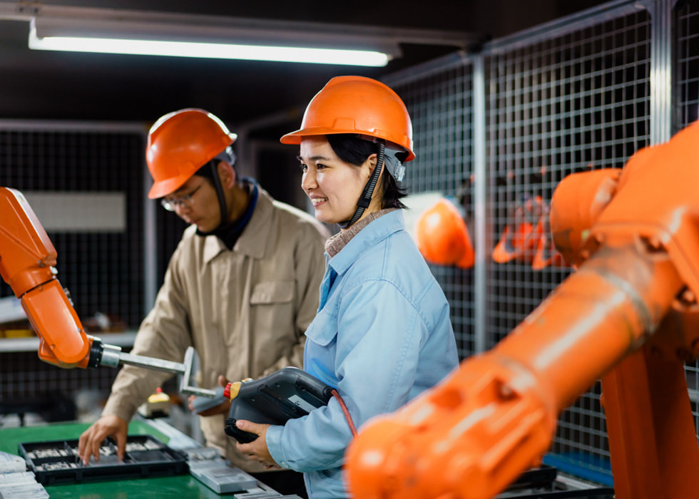 Baretli iki kişi laboratuvar ortamında çalışıyor.