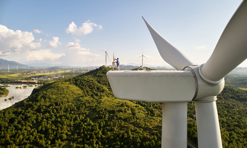 Een medewerker voert op grote hoogte reparaties uit aan een windturbine.