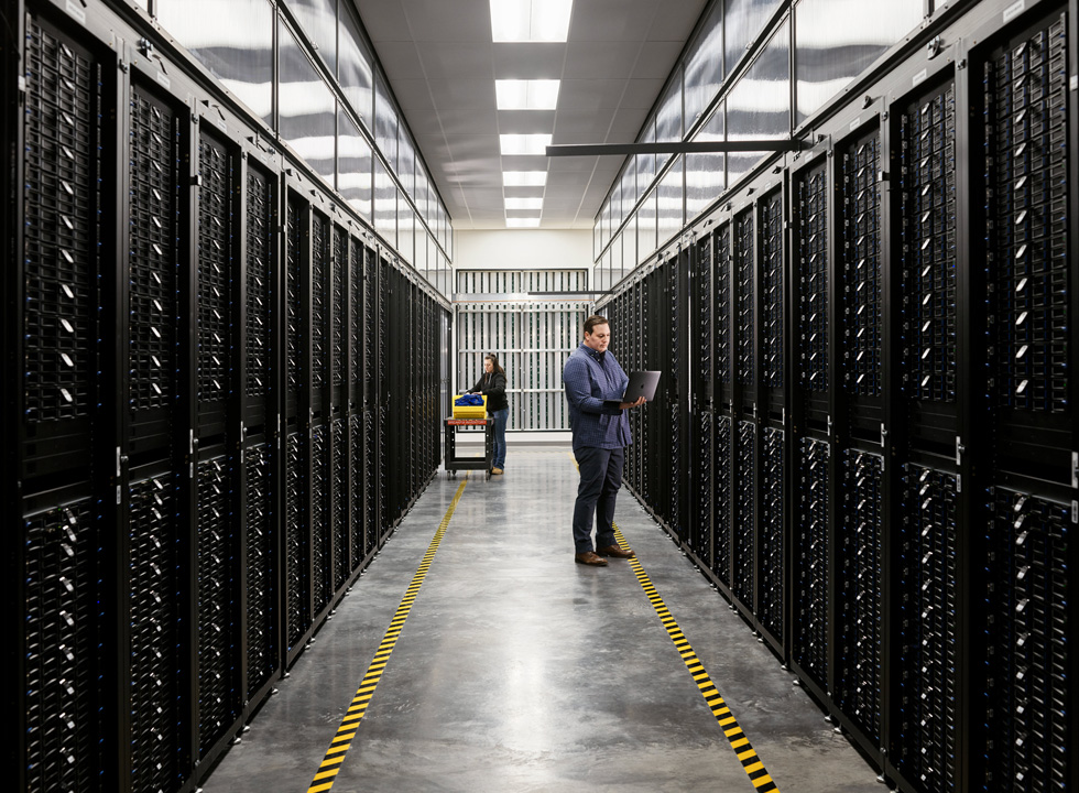 Twee medewerkers in een serverruimte van een datacenter van Apple.