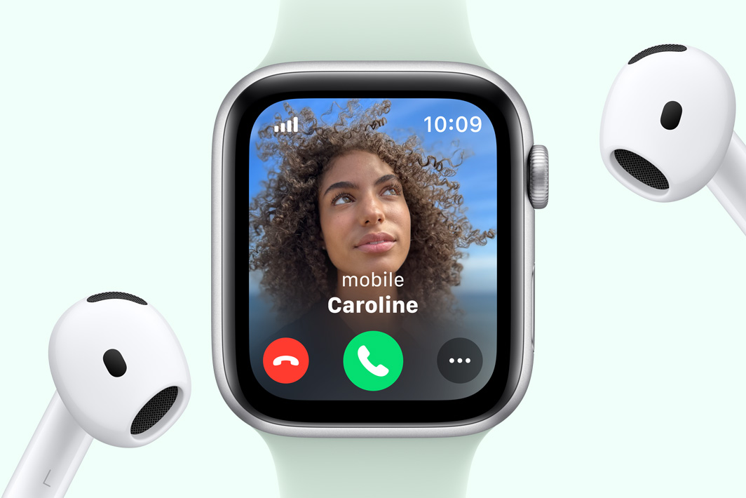 Apple Watch SE showing an incoming call, next to a pair of AirPods