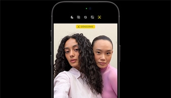 Siyah iPhone 18 Pro, önden görünüm, yüz takibi özelliğiyle iki kişinin görüntüsü, Ana Sahne ön kamera özelliği gösteriliyor
