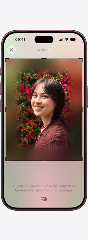 iPhone 18 Pro, önden dış görünümü, Uzamsal Yeniden Çerçeveleme özelliği, arkasında kırmızı güller olan bir kişinin yakın çekim fotoğrafını yeniden çerçevelemek için kullanılıyor