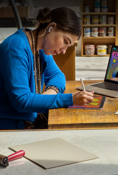 Eine Studentin an einem Schreibtisch zeichnet mit dem Apple Pencil auf einem iPad
