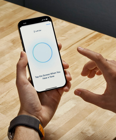 An AirPods Pro 2 user holds iPhone while using the new Hearing Test feature