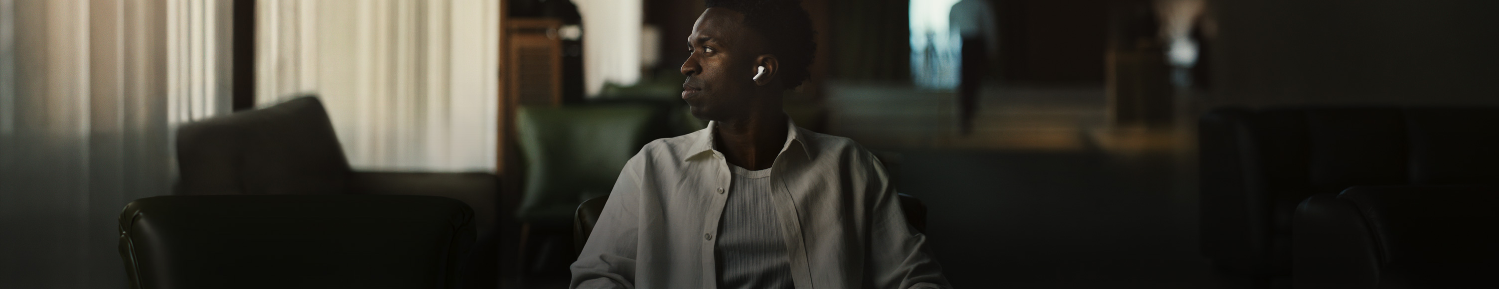 Una persona con una camisa blanca, se ve el audífono izquierdo de los AirPods Pro 3