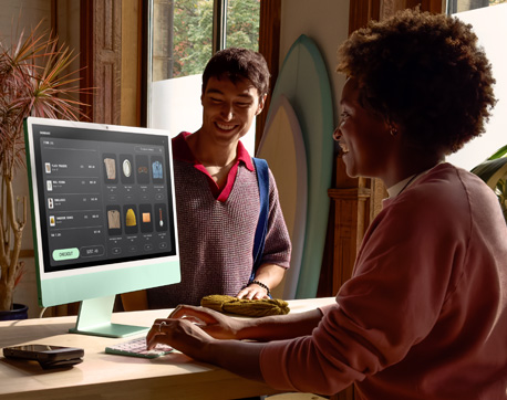 Twee mensen in een kamer met fel licht. Een vrouw gebruikt een iMac met een display met glas met nanotextuur, en een man zit daar vlakbij