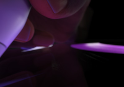 En hand håller i en Apple Pencil Pro för att skriva eller rita. Spetsen trycks mot en skärm och breda streck tecknas i lila.