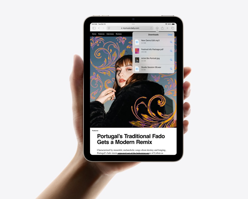 iPad mini držený jednou rukou na výšku, na něm zobrazená stahování v Safari.