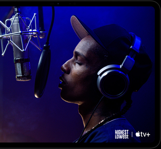 iPad Pro, Querformat, Vorderansicht, Farbe Space Schwarz, gerundete Ecken, schwarzer Displayrand, das Display zeigt Apple TV+ mit einer Szene aus dem Apple TV+ Original Highest 2 Lowest mit ASAP Rocky, der als Yung Felon in ein Mikrofon rappt