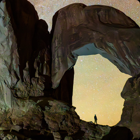 iPad Pro, Vorderansicht, das Display zeigt das Foto einer Person in einem Canyon vor einem Nachthimmel voller Sterne