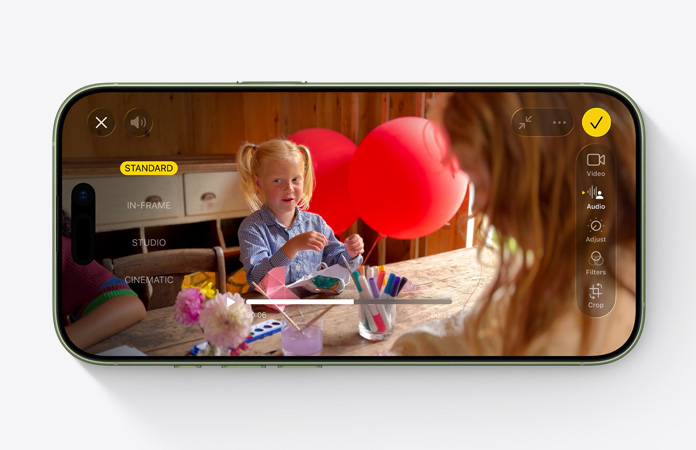 Pohled zepředu na iPhone 17, na kterém je vidět použití Audio Mixu při upravování videa s dítětem, které si hraje s balónky