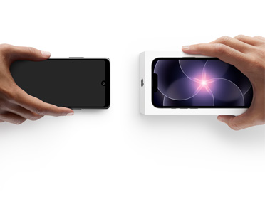 Hands exchanging phones, Android on the left without a box, on the right is a new iPhone 17 Pro in box