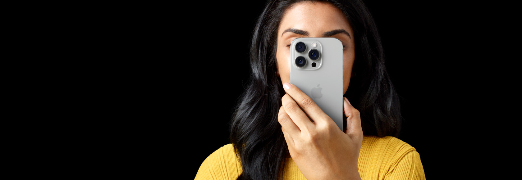 Une personne tenant un iPhone 16 Pro devant son visage.