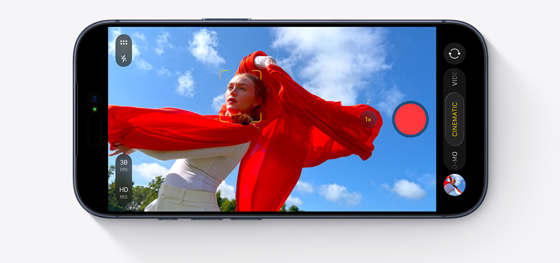 Ein iPhone Display zeigt den Kinomodus, der eine tanzende Person mit einem fliessenden roten Schal im Freien aufnimmt