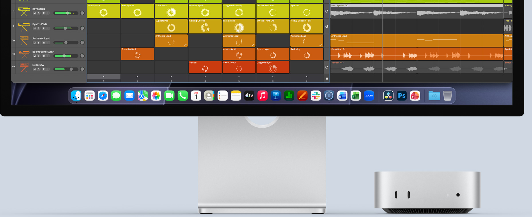 Parte frontal de una Mac mini ubicada debajo de un monitor Studio Display, la pantalla muestra la interfaz de Logic Pro y apps de productividad en el Dock en la parte inferior