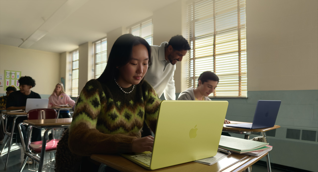 Une personne dans une classe utilise un MacBook Neo, couleur agrume, non branché 