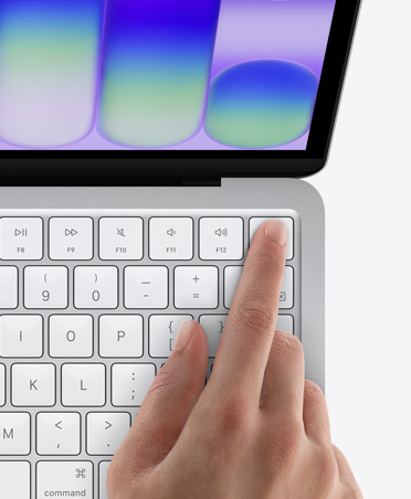 銀色 MacBook&nbsp;Neo，有個人以指尖觸碰鍵盤右上角的 Touch&nbsp;ID 感應器