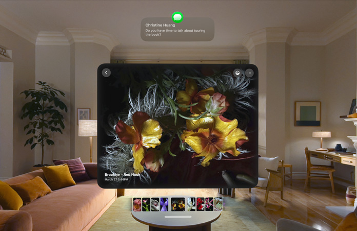 Apple Vision Pro expands a message about a book tour while displaying images of flowers